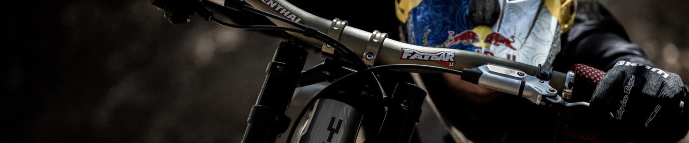マウンテンバイクのハンドルを握り、柄入りのヘルメットとグローブを身につけたマウンテンバイカー。.