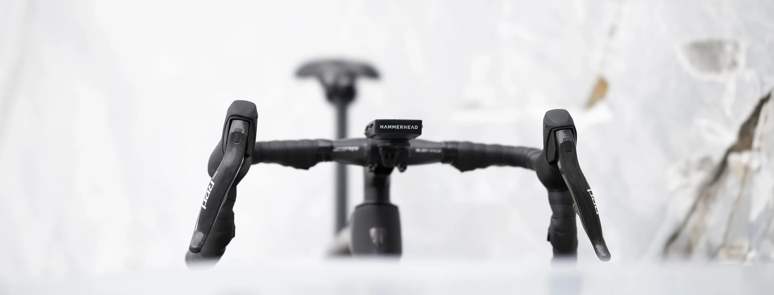 中央にHammerheadのサイクルコンピュータが取り付けられた自転車のハンドルのクローズアップ写真。.