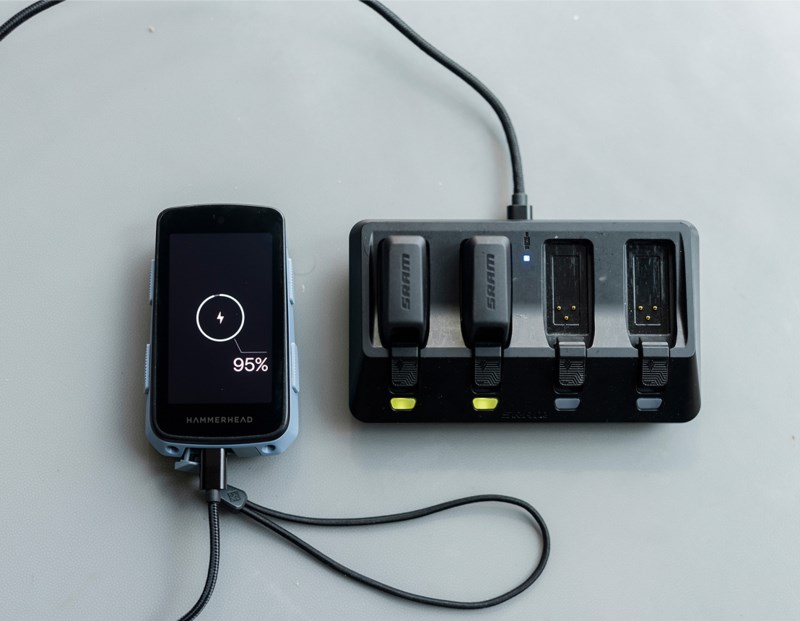 充電ドックの横に、充電残量95％のHammerheadサイクルコンピュータが置かれており、そのドックにはSRAM製バッテリーが2つ挿入されている。.