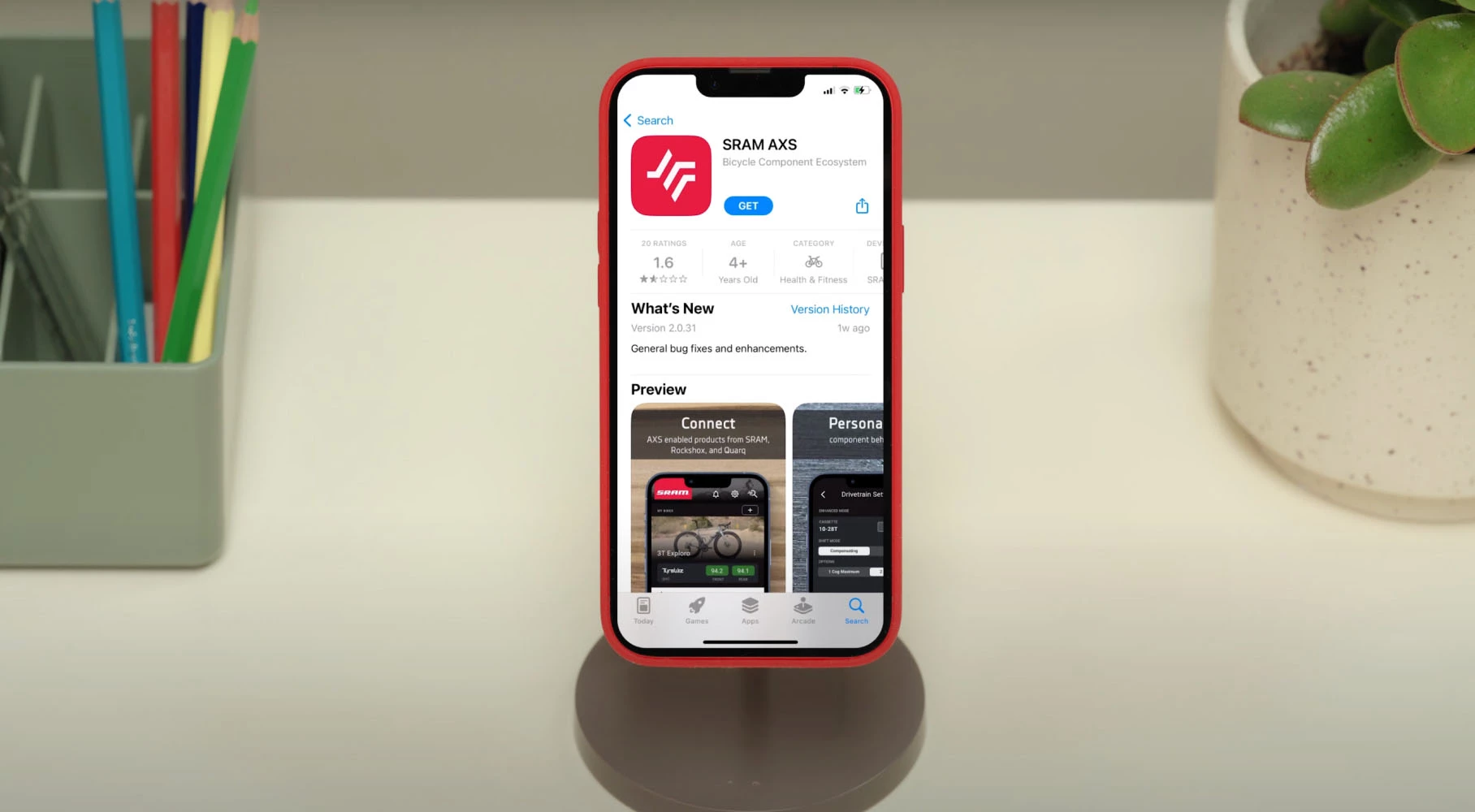 スタンドに置かれたスマートフォンに、SRAM AXSのアプリストアのページが表示されている。.
