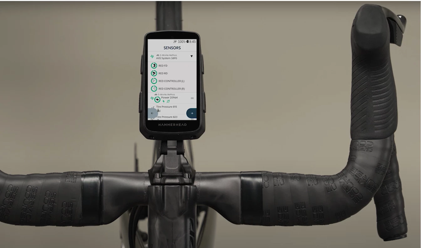 ハンドルバーに取り付けられた自転車用GPSコンピュータで、センサーの接続メニューが表示されている。.