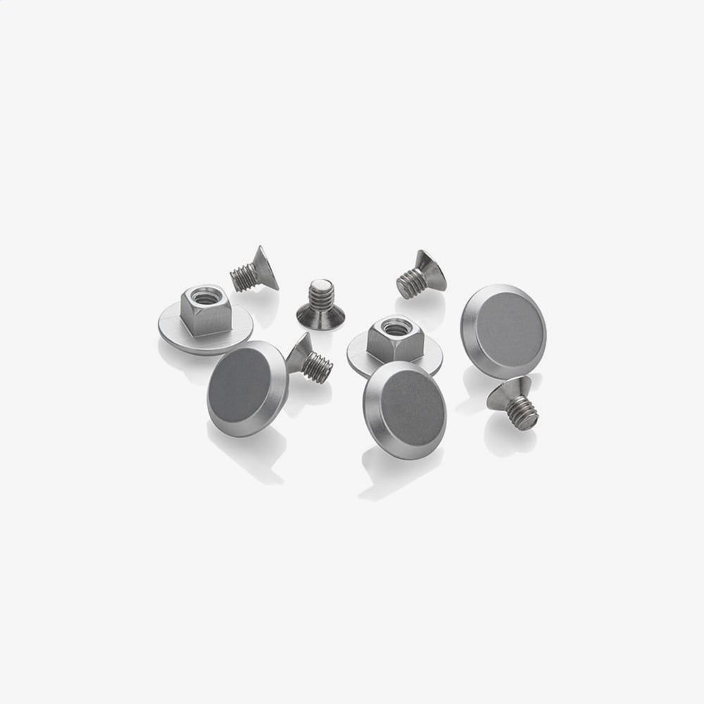 丸く平らで滑らかなトップのカンビウム・リベット・シルバー（CAMBIUM RIVET SILVER）が、白い表面に整然と並べられている。.