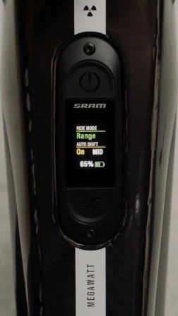 SRAMの自転車ディスプレイのクローズアップ。バッテリー残量65％、ライドモードはRange、オートシフトはOnかつMIDに設定されている。.