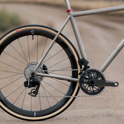 ダートコースを走るCOUNTY LINE ALL-ROAD BIKEのフレームの後方からの眺め。ディープセクションのカーボンホイールと1xドライブトレインを装備している。.