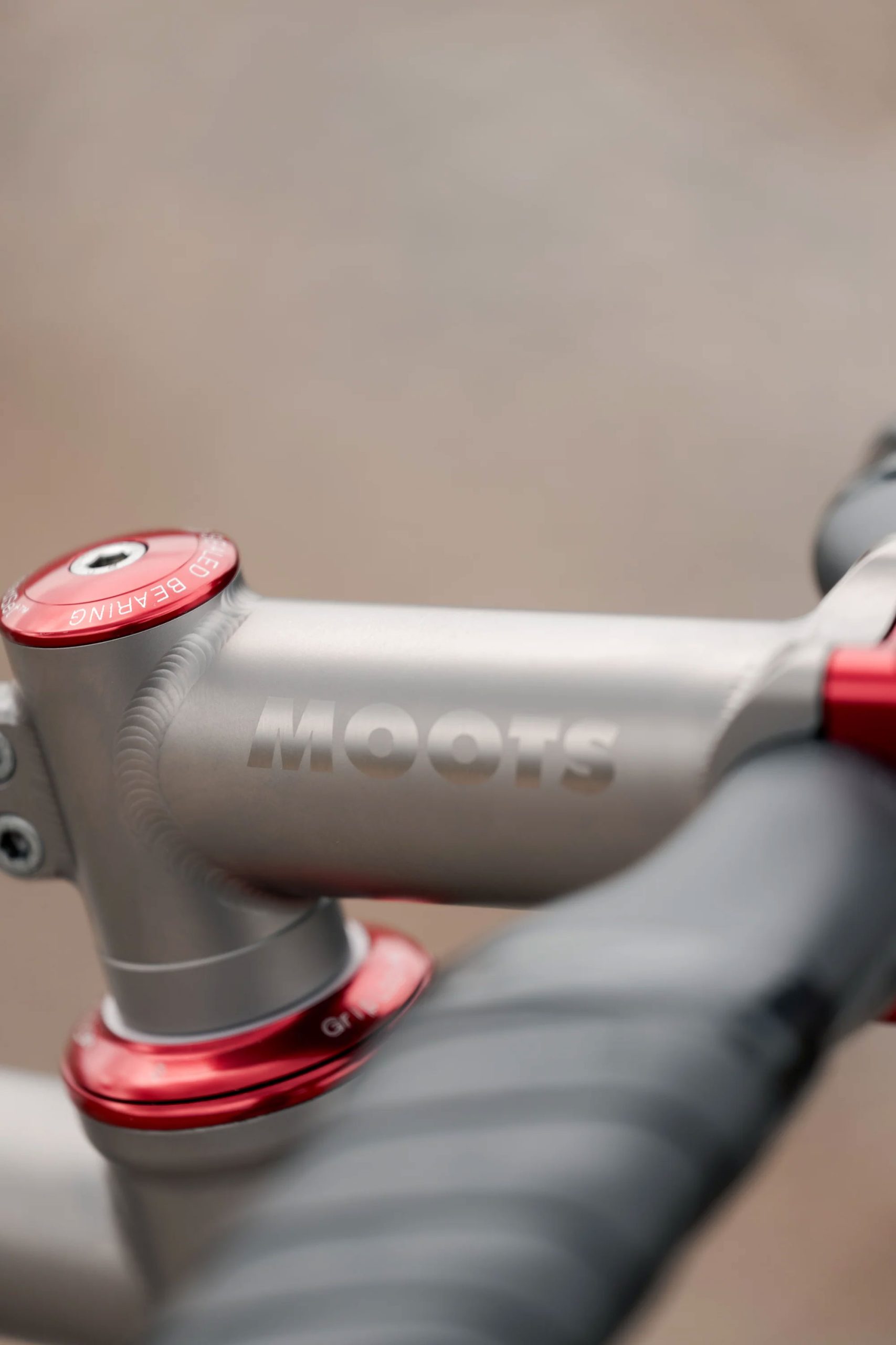 A33A1658 COUNTY LINE ALL-ROAD BIKEのステムとハンドルバー部分をクローズアップ。赤いアクセントとブランドロゴ入りの金属パーツが際立っています。.
