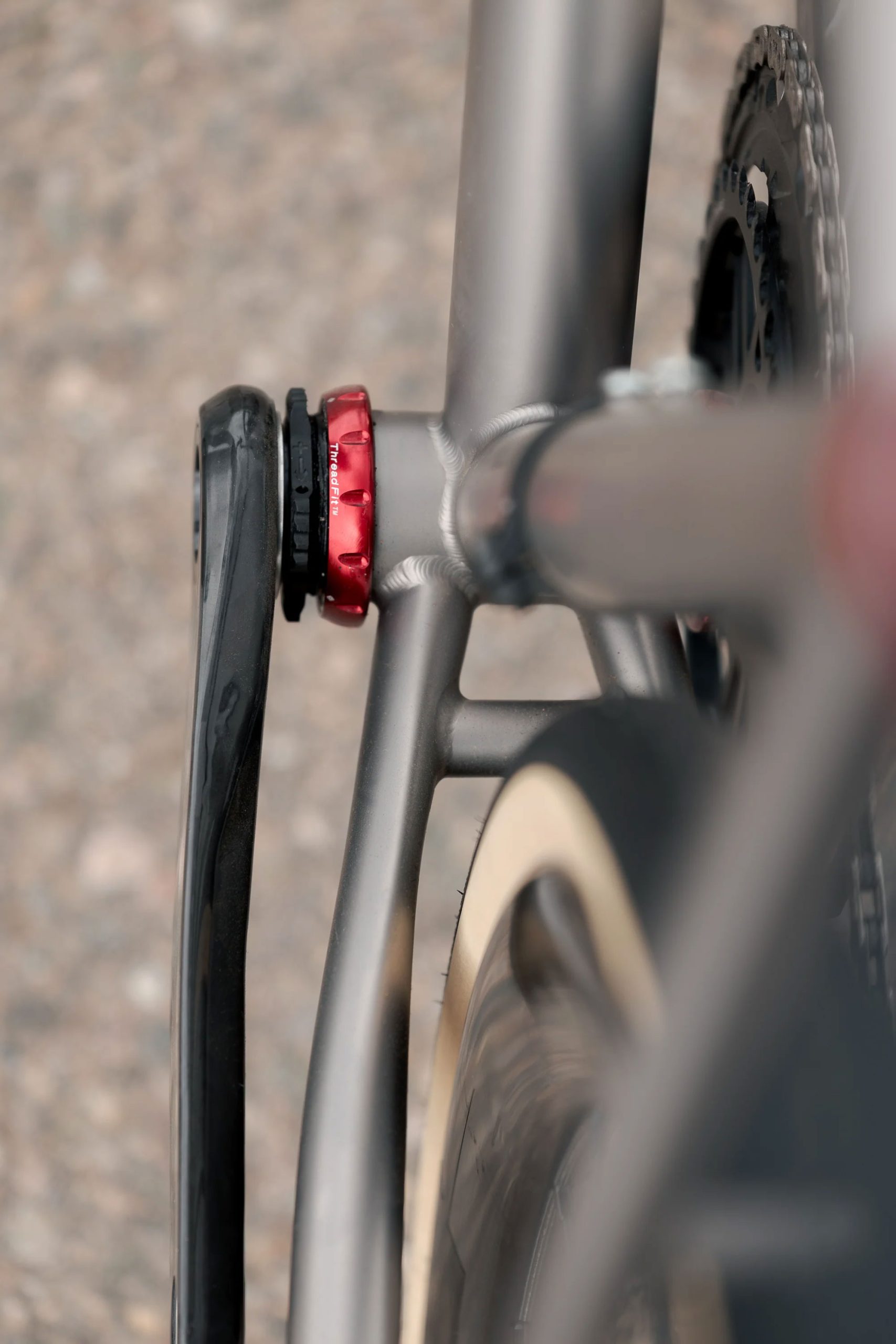 A33A1660 COUNTY LINE ALL-ROAD BIKEのフレームのボトムブラケット部分をクローズアップした写真。赤いロックリングと黒いクランクアームが見える。.