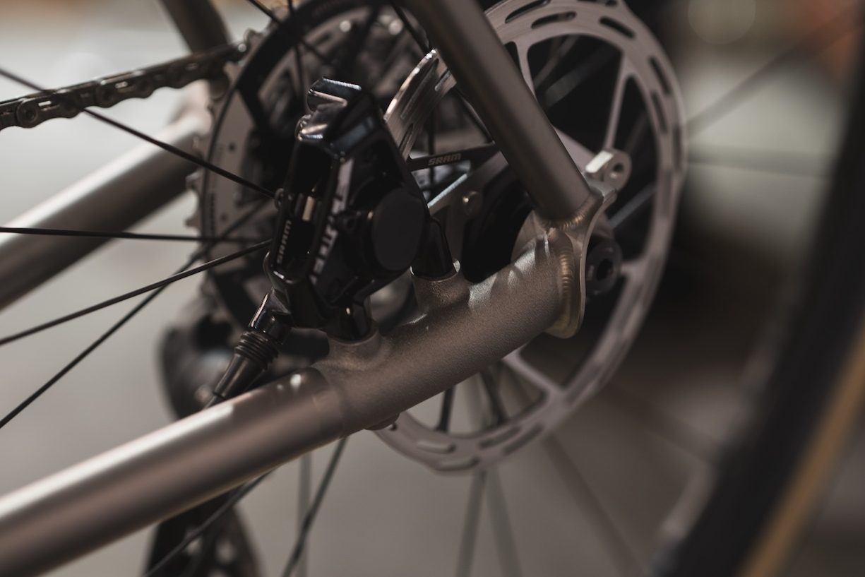 フレーム後部に装着された自転車のディスクブレーキアセンブリのクローズアップ。.
