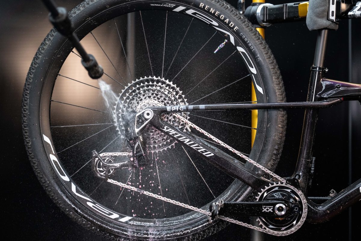 自転車の後輪とチェーンを水スプレーで洗浄しているところ。.