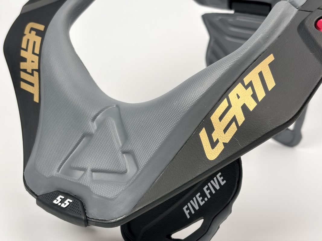 Leatt 5.5 ネックブレース。カラーはグレーとブラック、ロゴはゴールド。.