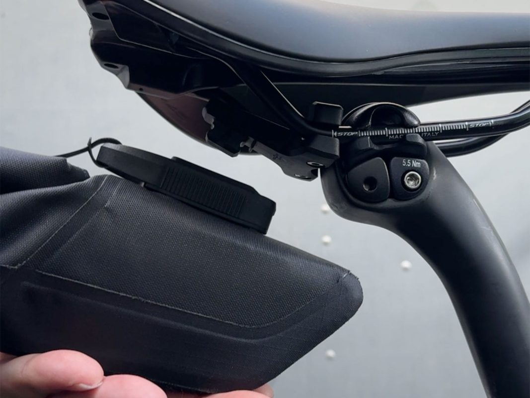 自転車のサドルの下側に、黒い収納バッグが取り付けられている。.