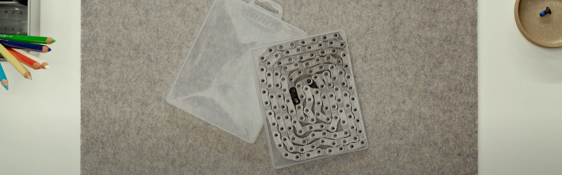 透明なプラスチック製の収納ケースの中に、自転車用のチェーンが巻き込まれている。.