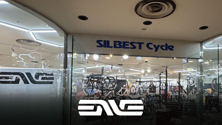 自転車店シルベスト・サイクルの店先。ガラス張りの入り口にはエンヴェのロゴが飾られている。.