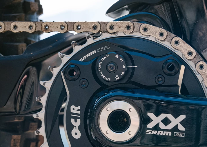 チェーンリングと外部トラベル調整ダイヤルを備えた、SRAM XXの自転車ドライブトレインのクローズアップ。.