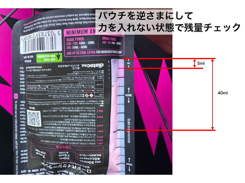 容量目盛りが付いた自転車用タイヤシーラントのパウチ。パウチを絞らずに逆さまにして、液体の残量を確認する方法を示しています。.