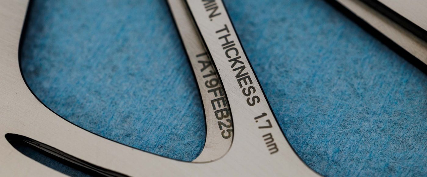 MIN. THICKNESS 1.7 mmおよびTA19FEB25という文字が刻印された金属部品。.