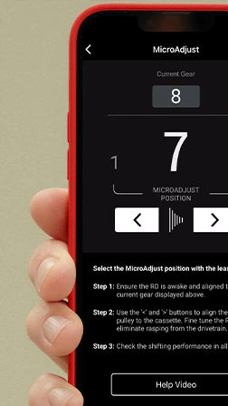 自転車のギア調整用MicroAdjustインターフェースが表示されたスマートフォンの画面。調整用の矢印と、手順ごとの説明が表示されている。.