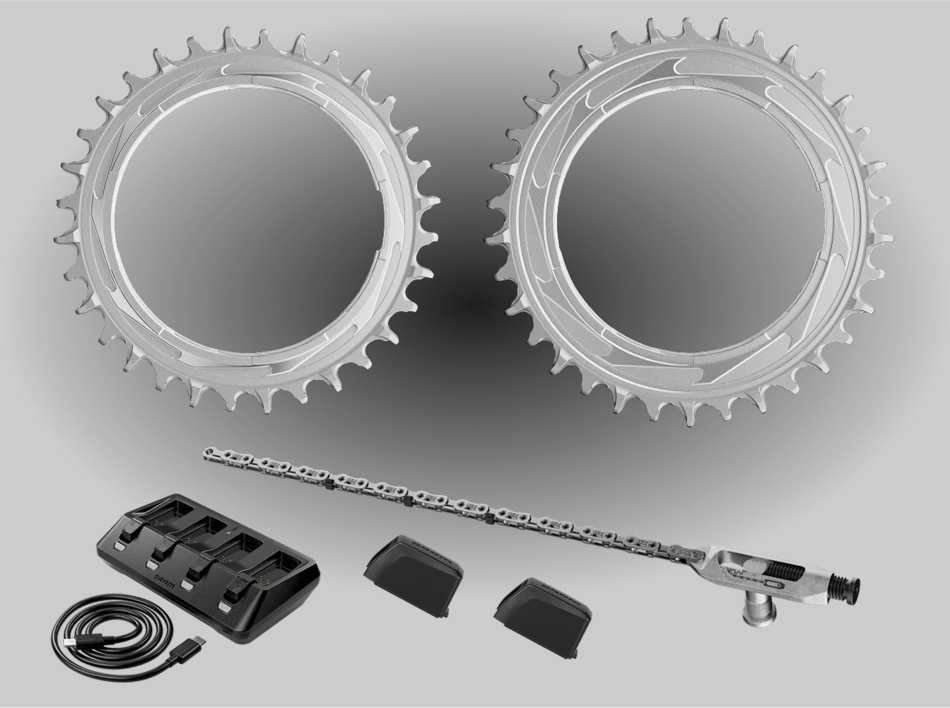 自転車用チェーンリング2個、ディレイラー付き自転車用チェーン、USBケーブル付きのマルチポートバッテリー充電器、そして小さな黒いバッテリーカバー2個。.