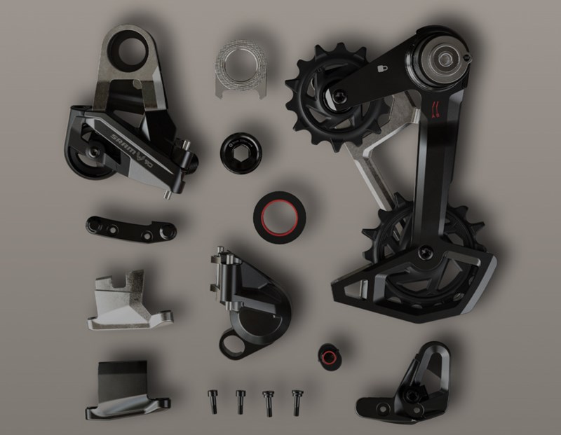 SRAM製マウンテンバイク用ディレイラーの分解部品が、平らな面に並べられている。.