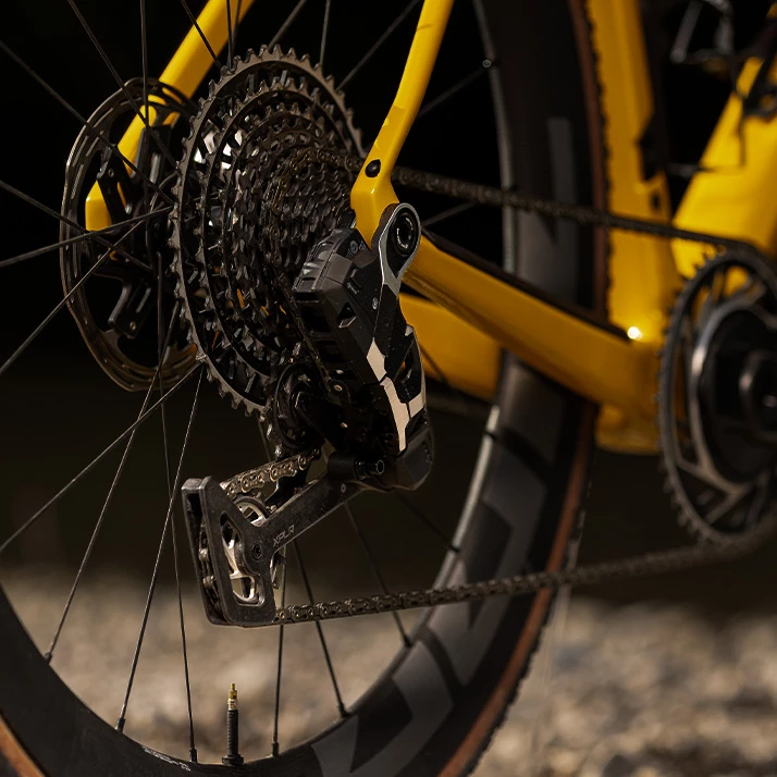黄色いフレームの自転車のリアディレイラー、カセット、チェーンのクローズアップ。.