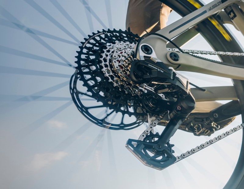 走行中の自転車のリアカセット、ディレイラー、チェーンのクローズアップ。.